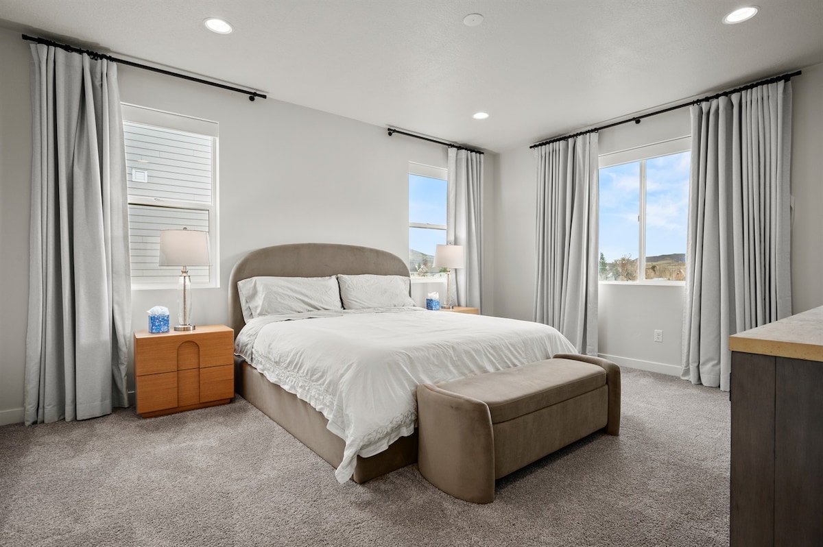 Oddýchnite si v hlavnej spálni na hlavnom poschodí, kde je manželská posteľ s luxusnou posteľnou bielizňou orámovaná tromi oknami vrátane veľkého dvojitého okna s úchvatným výhľadom na hory.