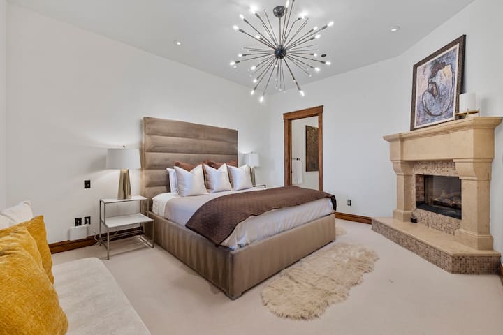 vierassviitti, jossa on queen-vuode, kattokruunu ja suuri kivitakka