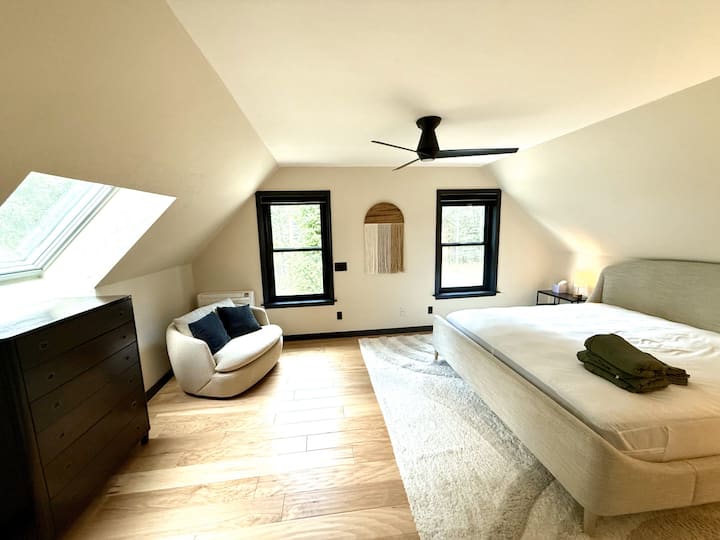 Dormitorio principal con una cama tamaño king y baño privado en suite: tu propio refugio cómodo para relajarte y descansar.