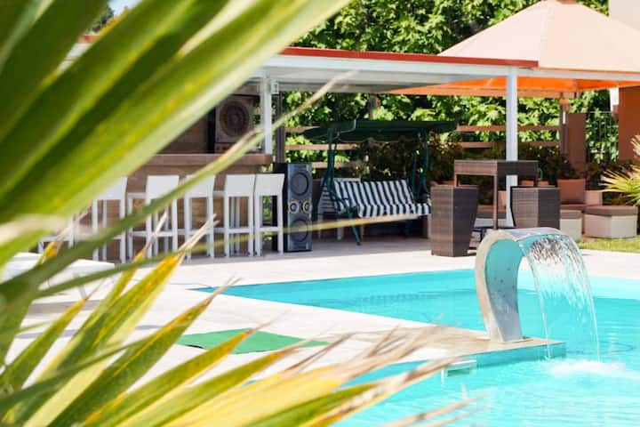 Piscina en el hotel con tumbonas: área de la piscina principal con tumbonas a la sombra.

