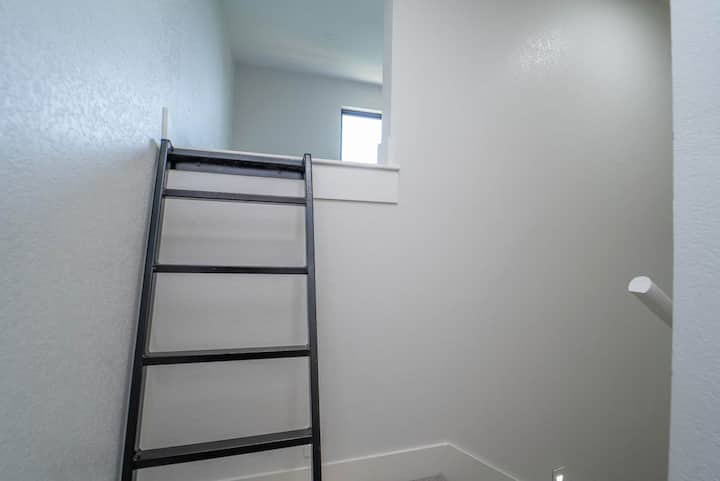 Architektonický detail. Súhra svetla a tieňa, jemné textúry stien a jednoduchá elegancia rebríka.