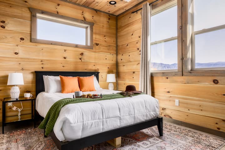 Middle level queen bedroom with an ensuite bathroom, TV and luxury linens