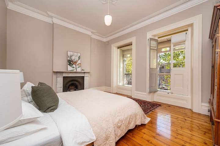 Dormitorio uno con acceso al balcón y chimenea ornamental 