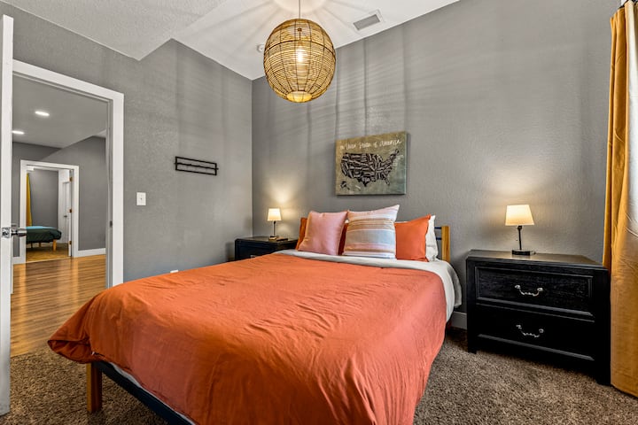 - Удобна брачна спална соба со живописна портокалова постелнина и стилско висечко светло
- Неутралните сиви ѕидови прават акцентите во боја да се појават и да се чувствуваат привлечно
- Соодветните светилки и ѕидната уметност создаваат урамнотежен модерен простор