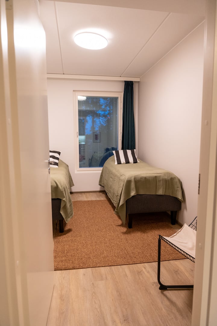 تحتوي غرفة النوم الثانية على كرسي بذراعين وسريرين مفردين بعرض 80 سم، يمكن تجميعهما معًا مقابل سرير مزدوج