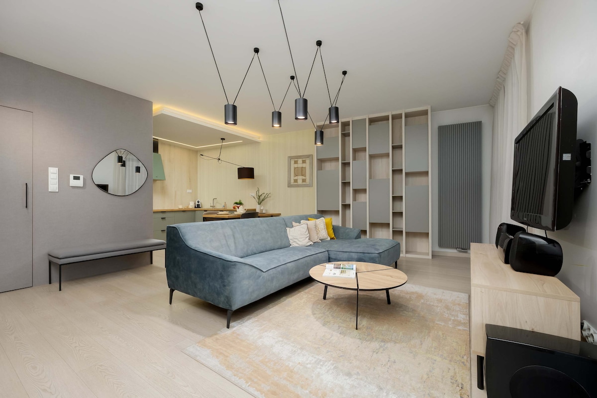 Priestranná obývacia izba s mäkkou pohovkou a veľkým televízorom vás pozýva na oddych po dni plnom zážitkov.