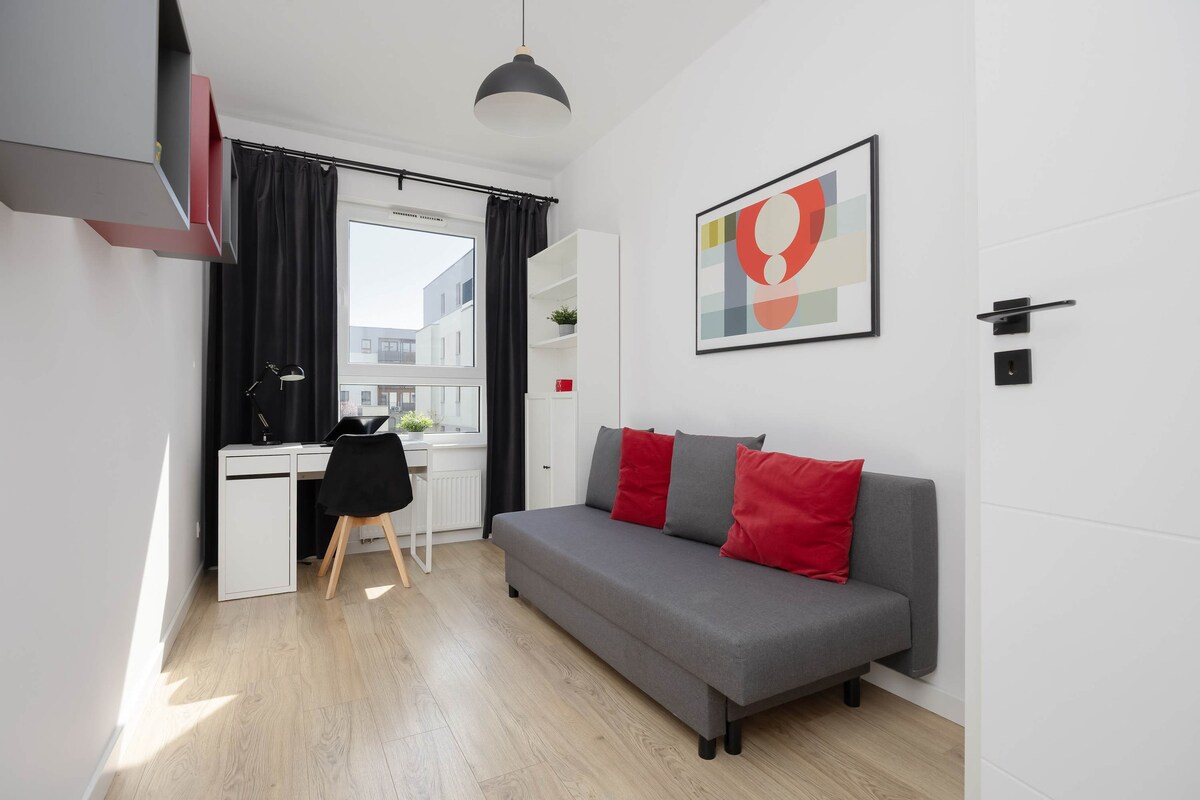 Een kamer ingericht met een slaapbank en minimalistische kunst, perfect voor ontspanning of extra slaapruimte.