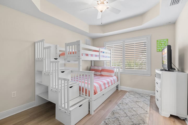 Двоспальне ліжко над повноцінним двоярусним ліжком і ванною кімнатою з двома односпальними ліжками