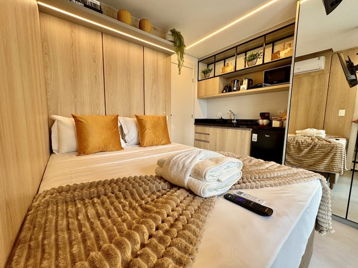 Cama de dos plazas con manta y almohadas color caramelo