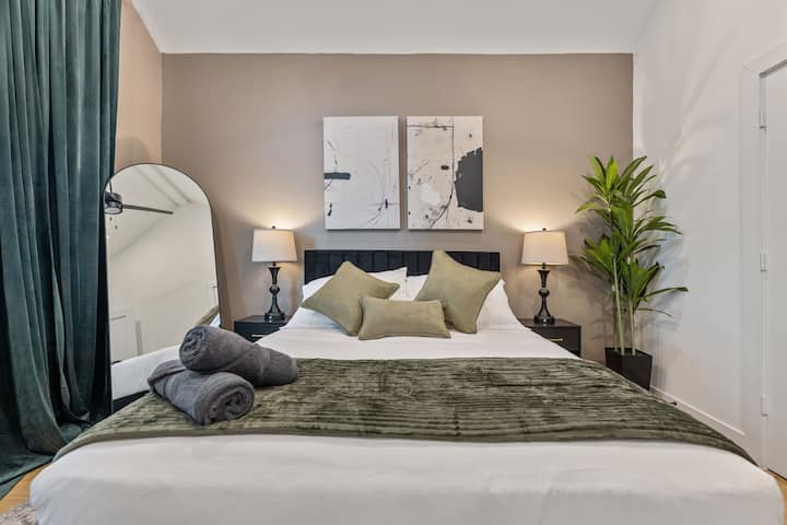 Dormitorio principal acogedor con ropa de cama lujosa e iluminación cálida
