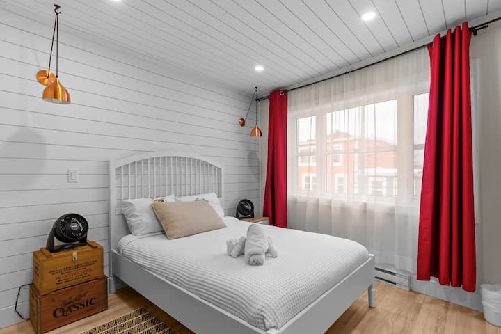 Уште една прекрасна опција за спална соба, со бел кревет и малку боја од завесите.