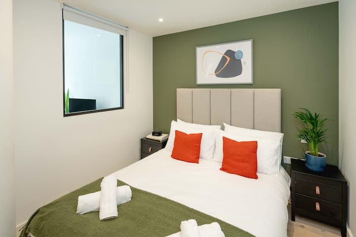 מיטת קינג סייז מרווחת עם נוף לגינה ומבטאים נועזים. 