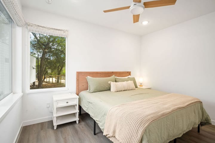 El dormitorio 6 está en la unidad 8 y muestra una cama tamaño king con sábanas acogedoras y grandes ventanales con persianas opacas.