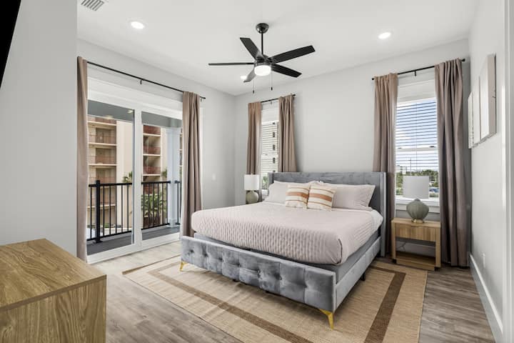 Elegante dormitorio con TV montado y cortinas opacas