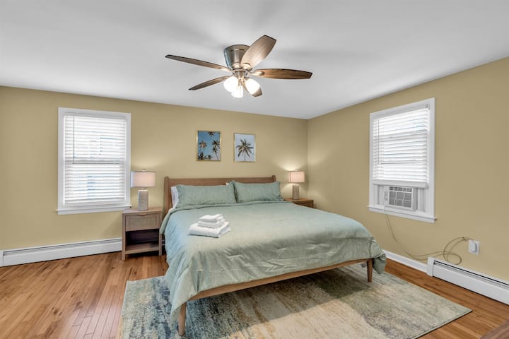 The king bedroom with an en-suite bathroom, ceiling fan and a window A/C unit