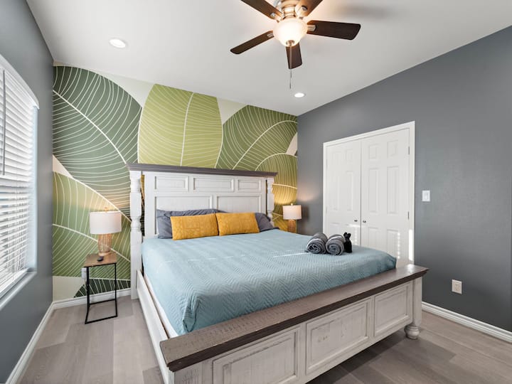 Bedroom 1: King bed with bold tropical flair drift off in comfort under calming tones and designer touches.