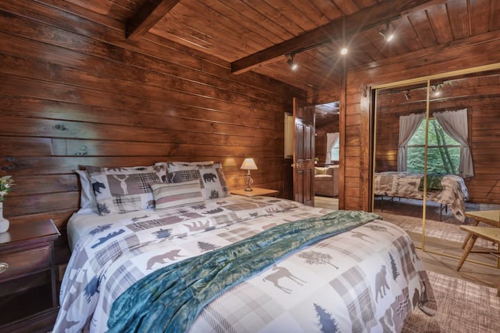 Furahia usiku wa starehe katika chumba hiki cha kulala cha kupendeza cha nyumba ya mbao kilicho ️ na kuta za mbao za kijijini, matandiko yenye starehe yenye ruwaza zilizohamasishwa na mazingira ya asili na mwonekano wa msitu wa amani unaoonyeshwa kwenye milango ya kabati iliyoangaziwa ✨
