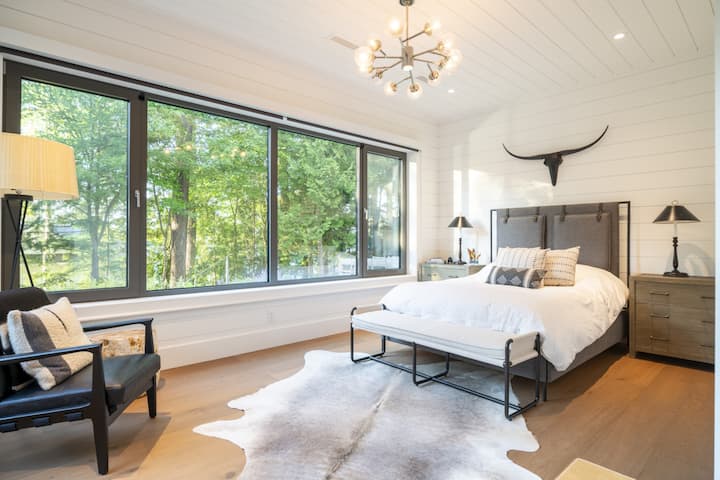 غرفة نوم في الطابق السفلي مع الكثير من الضوء الطبيعي