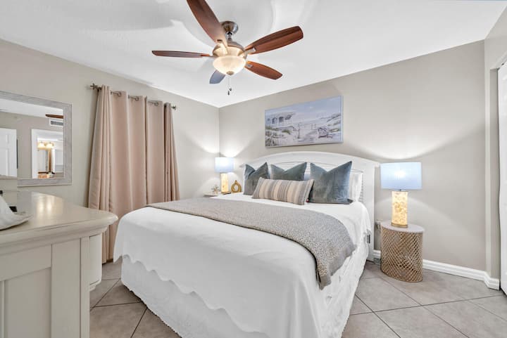 Relájese en este tranquilo dormitorio principal con sábanas lujosas, la suave brisa del ventilador de techo y una iluminación tenue que crea su santuario perfecto para dormir.