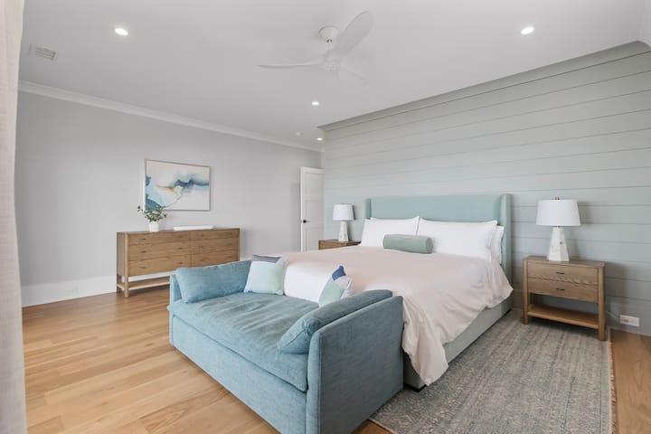The primary bedroom features a California king bed, TV, ensuite bathroom and a daybed.