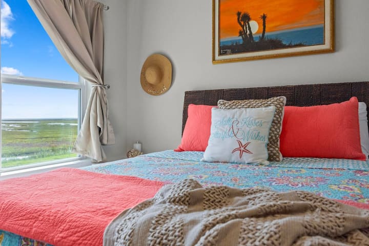 Relájate en nuestro acogedor dormitorio costero, con una lujosa cama adornada con una almohada "Salty Kisses, Starfish Wishes" y serenas vistas a los pantanos. Perfecto para un tranquilo refugio junto al mar.