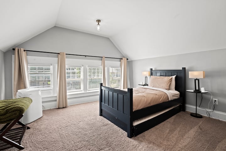 חדר שינה בקומה השלישית עם מיטה זוגית ושתי מיטות יחיד