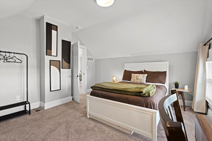 חדר שינה בקומה השלישית עם מיטת קווין סייז ושולחן עבודה