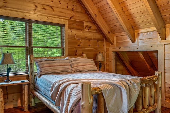 Loftová spálňa s manželskou posteľou, šatníkom, televízorom, komodou a vlastnou kúpeľňou. 