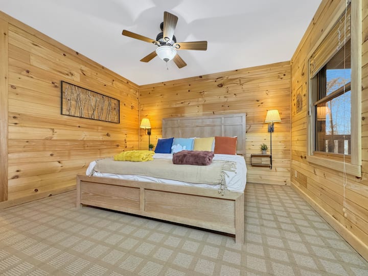 חדר שינה קינג מס '2: קירות עץ שטופי שמש ומיטת קינג סייז מפוארת יוצרים מפלט שליו בטבע.