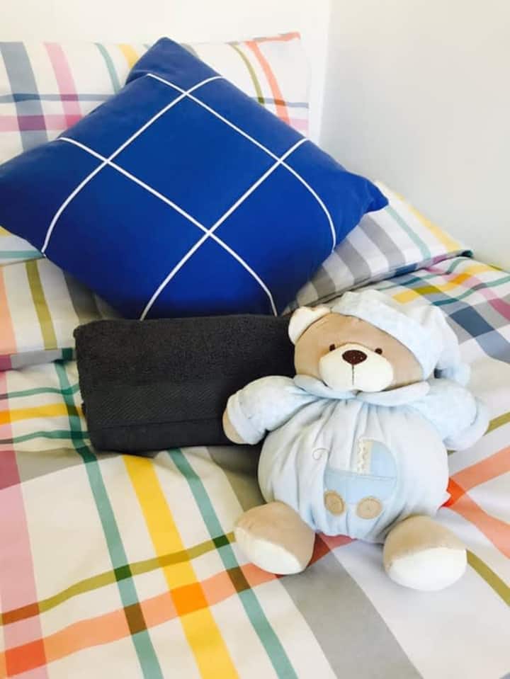 Tercer dormitorio con televisor inteligente montado en la pared.