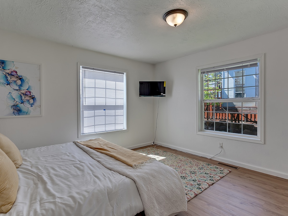 Bedroom 3 with king bed, colorful rug, and dual windows