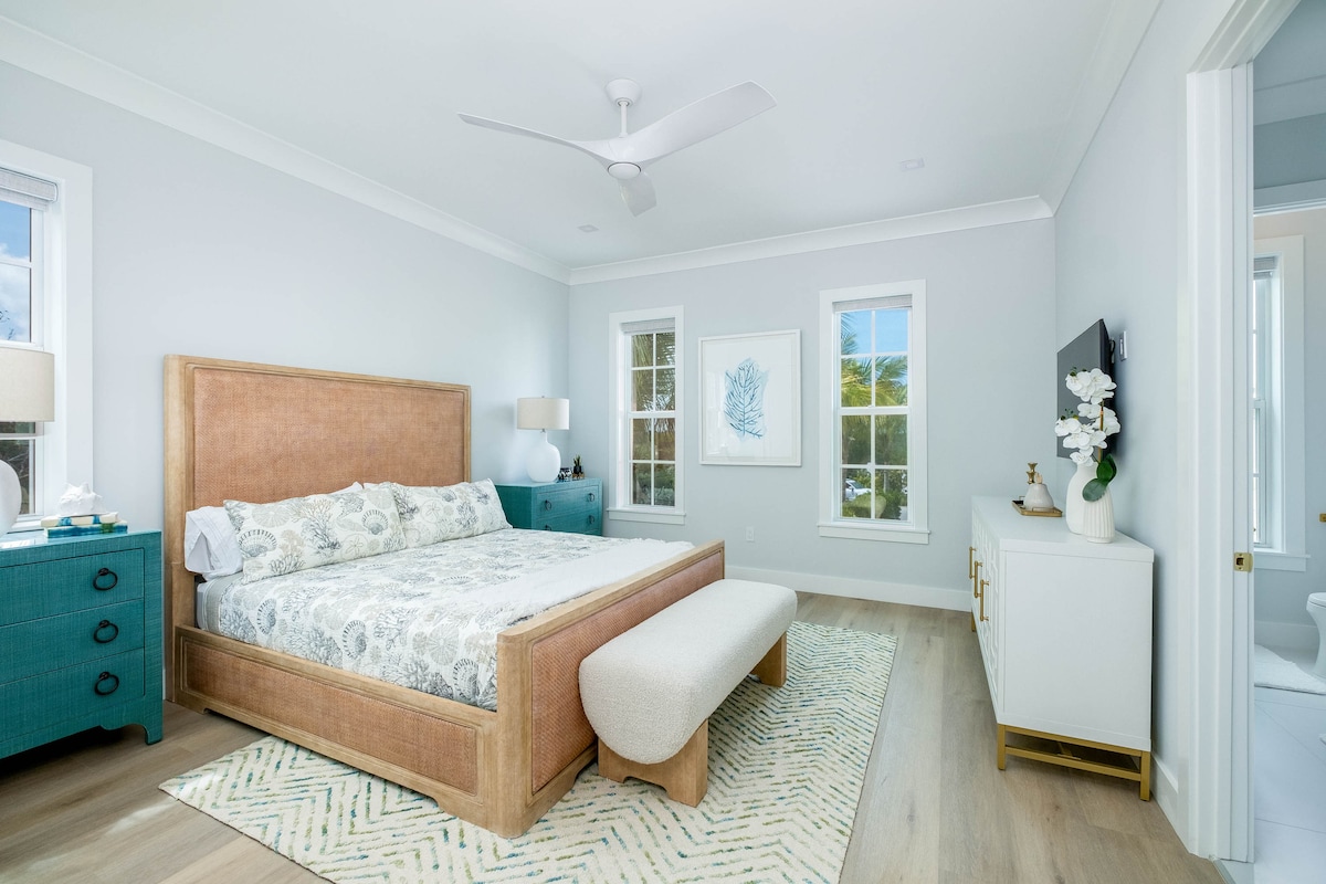 Serene bedroom in a Marathon Middle Keys coastal home with woven textures, soft neutral tones and light-filled windows. A SeaGlass Cove retreat close to Sombrero Reef snorkeling tours, coral viewing platforms and family-friendly ocean adventures.