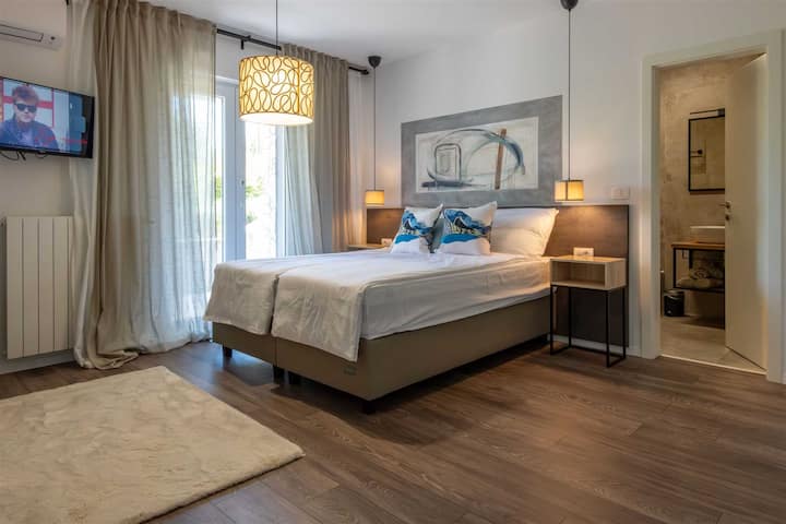 Во оваа двокреветна спална соба ве очекуваат кадифена постелнина и релаксирачки декор.