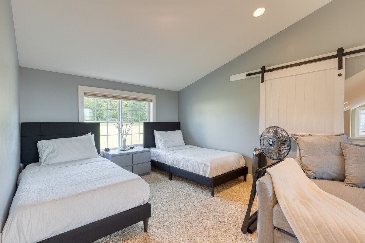 2号卧室配有2张单人床、沙发、电视和书桌。