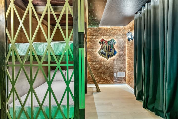 Adéntrate en una habitación con literas única, con una llamativa puerta verde que añade un toque divertido a las paredes rústicas de ladrillo. Las acogedoras camas están rodeadas de cortinas suaves y oscuras, lo que crea un ambiente íntimo perfecto para noches de descanso.