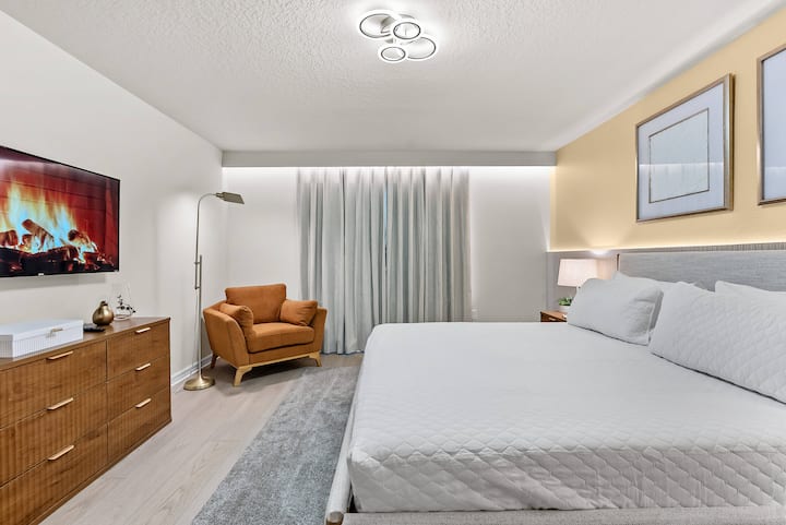 Relájate en esta recámara serena, equipada con una lujosa cama tamaño queen y con tonos neutros relajantes. Disfruta del acogedor sillón, la elegante cómoda y la iluminación moderna, y relájate con una exhibición de chimenea en la televisión después de las aventuras del día.
