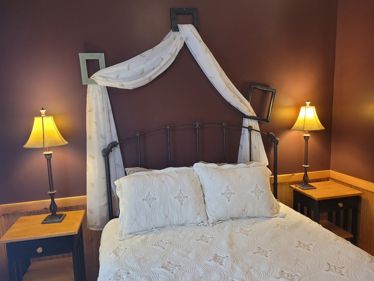 חדר שינה מס' 1 (קומת הקרקע): כולל מיטת קווין סייז, שידה, מראה, שידות לילה ומנורות.