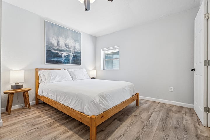 Dormitorio queen de estilo escandinavo con iluminación suave y decoración limpia y minimalista.