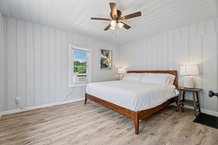 Suite principal con comodidad tamaño king y marco de madera clásico, ideal para relajarse después de un día ajetreado