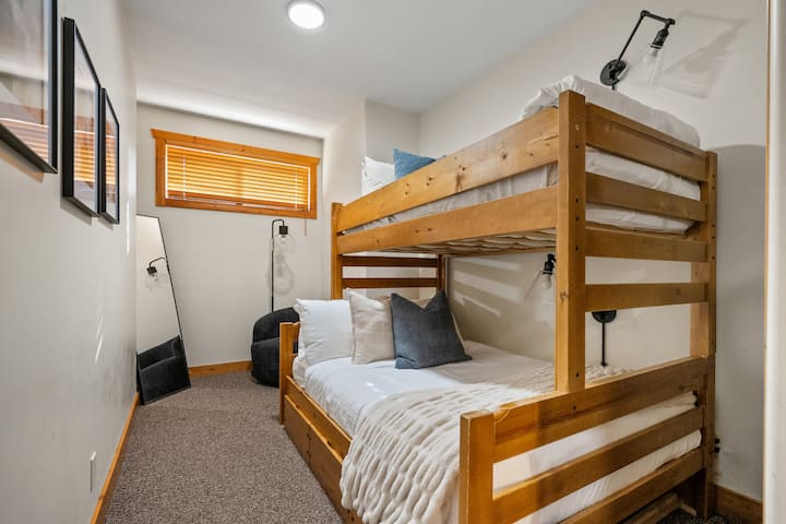 ห้องนอนห้องที่ห้าตั้งอยู่ชั้นล่างพร้อมเตียงสองชั้นแบบเตียงเดี่ยวอยู่บนเตียงคู่