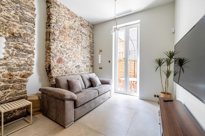 Красива всекидневна с разтегателен диван, телевизор с плосък екран.