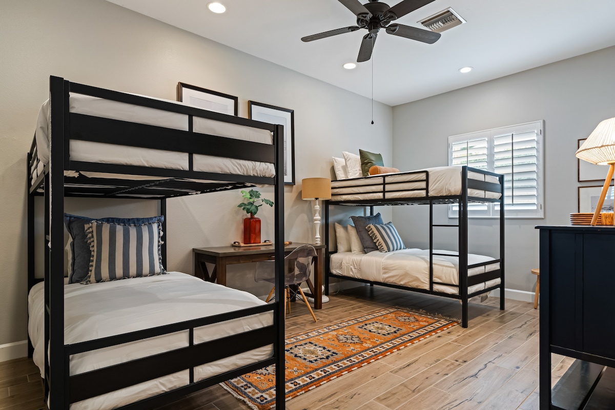 Slaapkamer 3 heeft 2 stapelbedden, een bureau en een eigen badkamer.