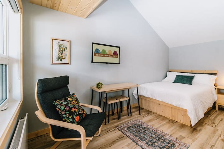 Main floor - Double bed, stacking table and stools, lounge chair, smart tv