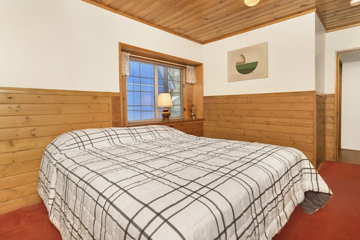 Спокойна спалня в дървена колиба с плюшено спално бельо и красиви гледки – идеална за спокойни нощи, уютни сутрини и релаксираща планинска почивка.