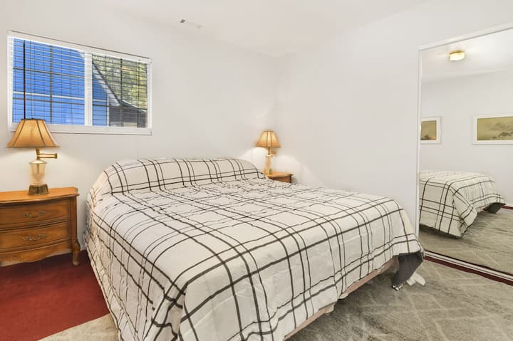 Спокойна спалня в дървена колиба с плюшено спално бельо и красиви гледки – идеална за спокойни нощи, уютни сутрини и релаксираща планинска почивка.