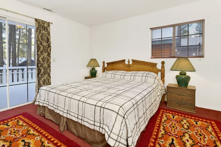 Спокойна спалня в дървена колиба с плюшено спално бельо и красиви гледки – идеална за спокойни нощи, уютни сутрини и релаксираща планинска почивка.