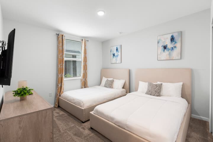 Dhomë gjumi dytësore me dy krevate të plotë dhe televizor me ekran të sheshtë