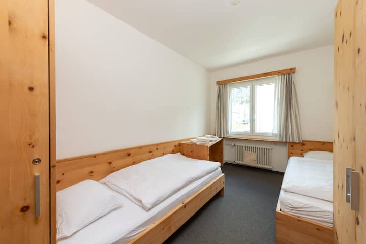 Chumba cha kulala cha Twin kilicho na Mionekano ya Mlima Chumba pacha cha kulala chenye starehe, kinachofaa kwa watoto au marafiki, kilicho na mashuka safi na mandhari ya milima kwa ajili ya mapumziko ya amani.