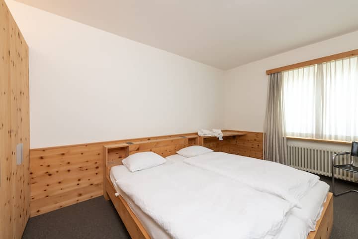 Chumba cha kulala chenye joto na cha kuvutia cha Kupumzika katika chumba hiki cha kulala chenye starehe cha watu wawili, kilicho na maelezo ya mbao za kijijini na mashuka safi kwa ajili ya kulala vizuri usiku.