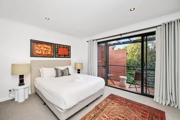 להירגע בנוחות. חדר שינה מודרני עם גישה למרפסת